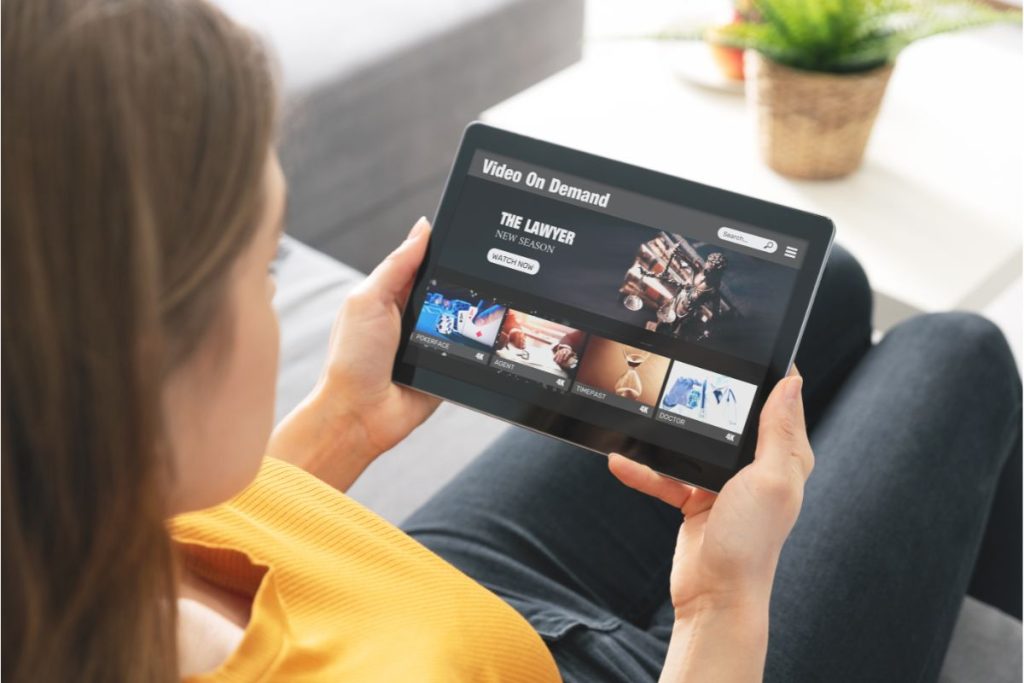 jeune femme accédant à une plateforme de streaming légal sur sa tablette