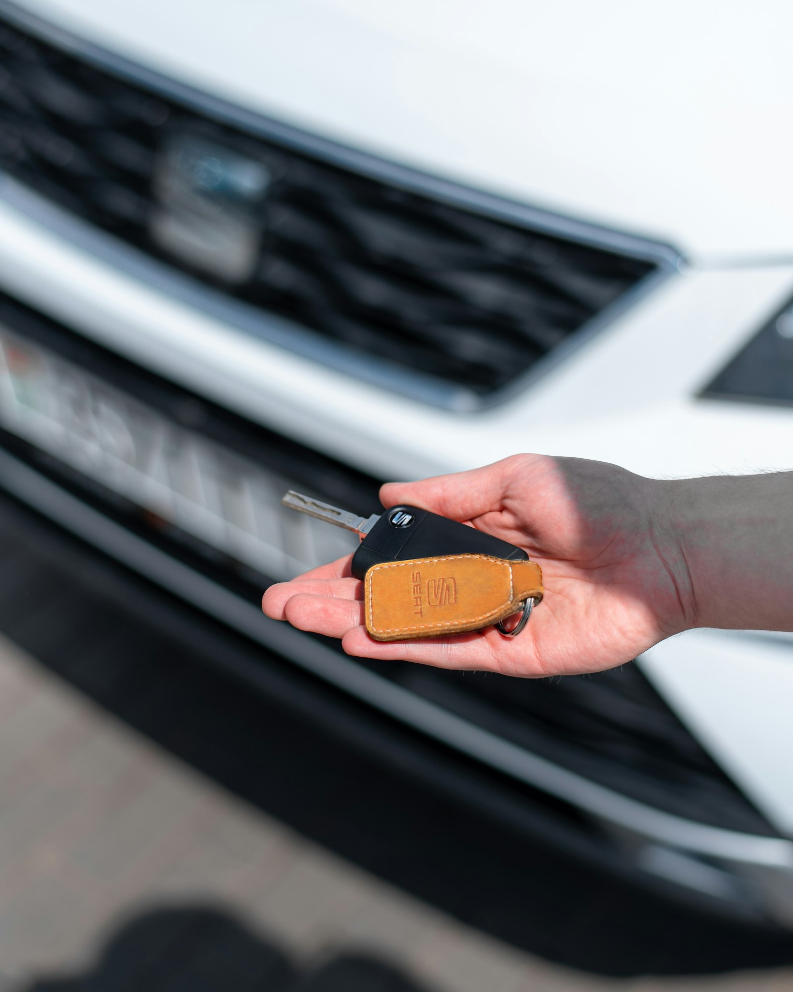 Personne tenant les clés d'une voiture neuve, illustrant l'achat via un mandataire automobile