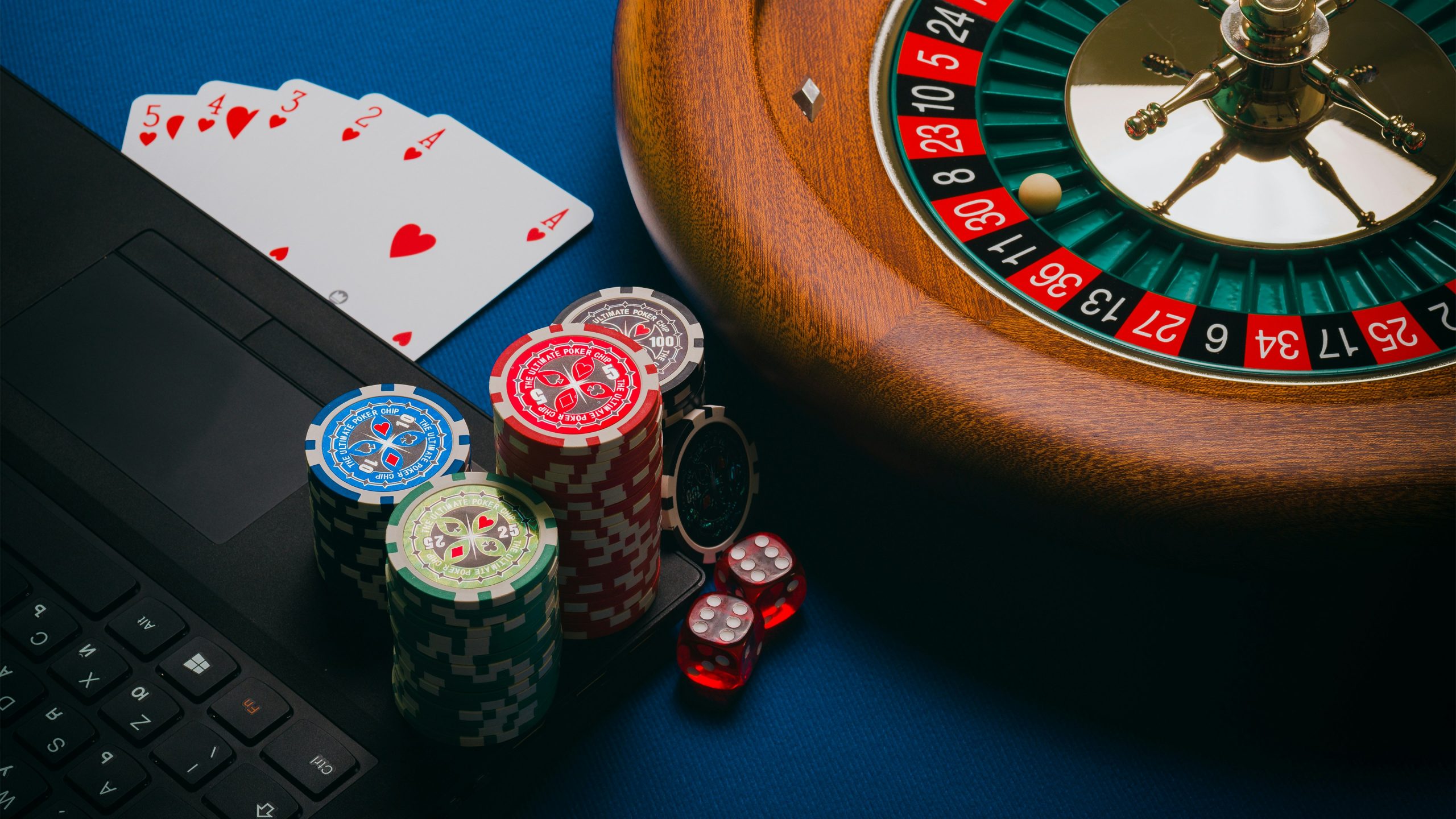 Roulette de casino et jetons posés sur un clavier d'ordinateur portable, symbole du jeu en ligne