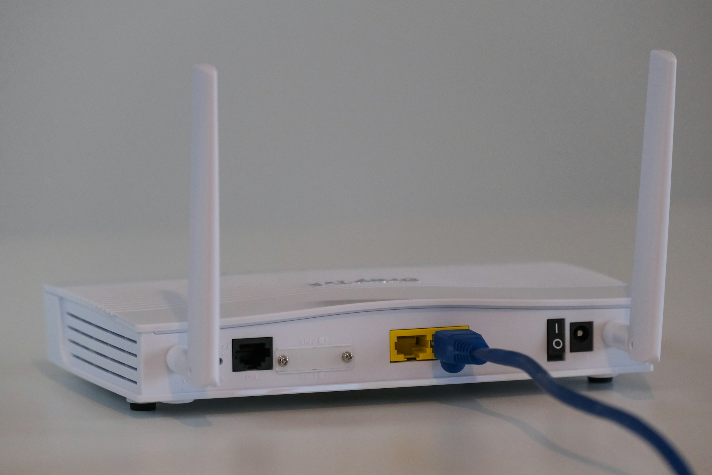 Box internet fibre blanche posée sur une table dans un salon