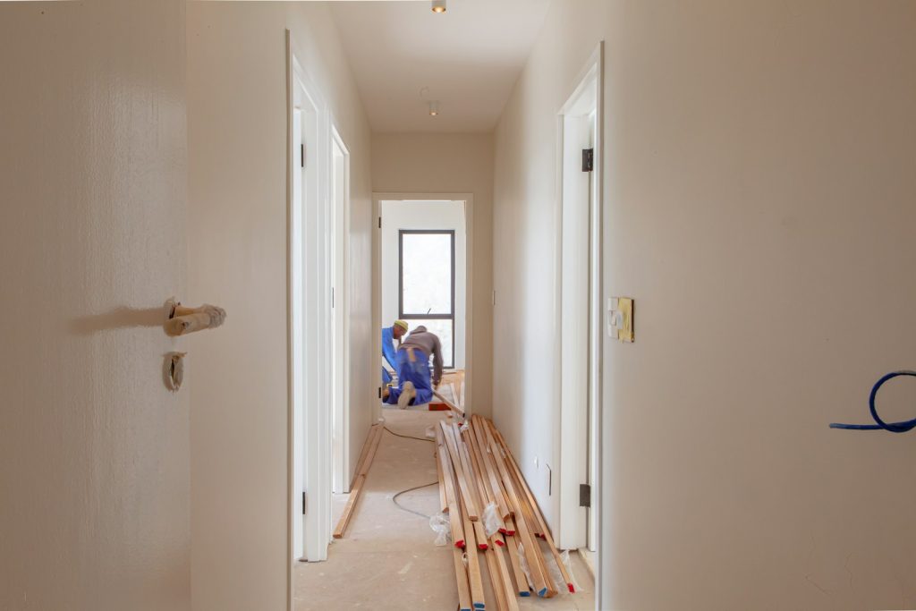Deux artisans réalisant des travaux de rénovation énergétique sur une maison
