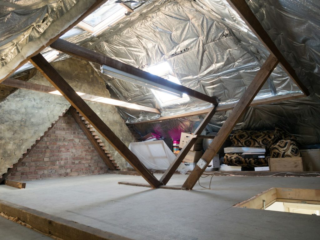 Combles d'une maison isolés, charpente et espace de stockage visibles