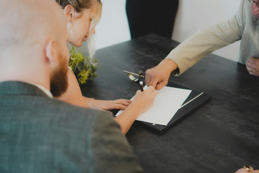 Couple signant un contrat d'assurance à un bureau