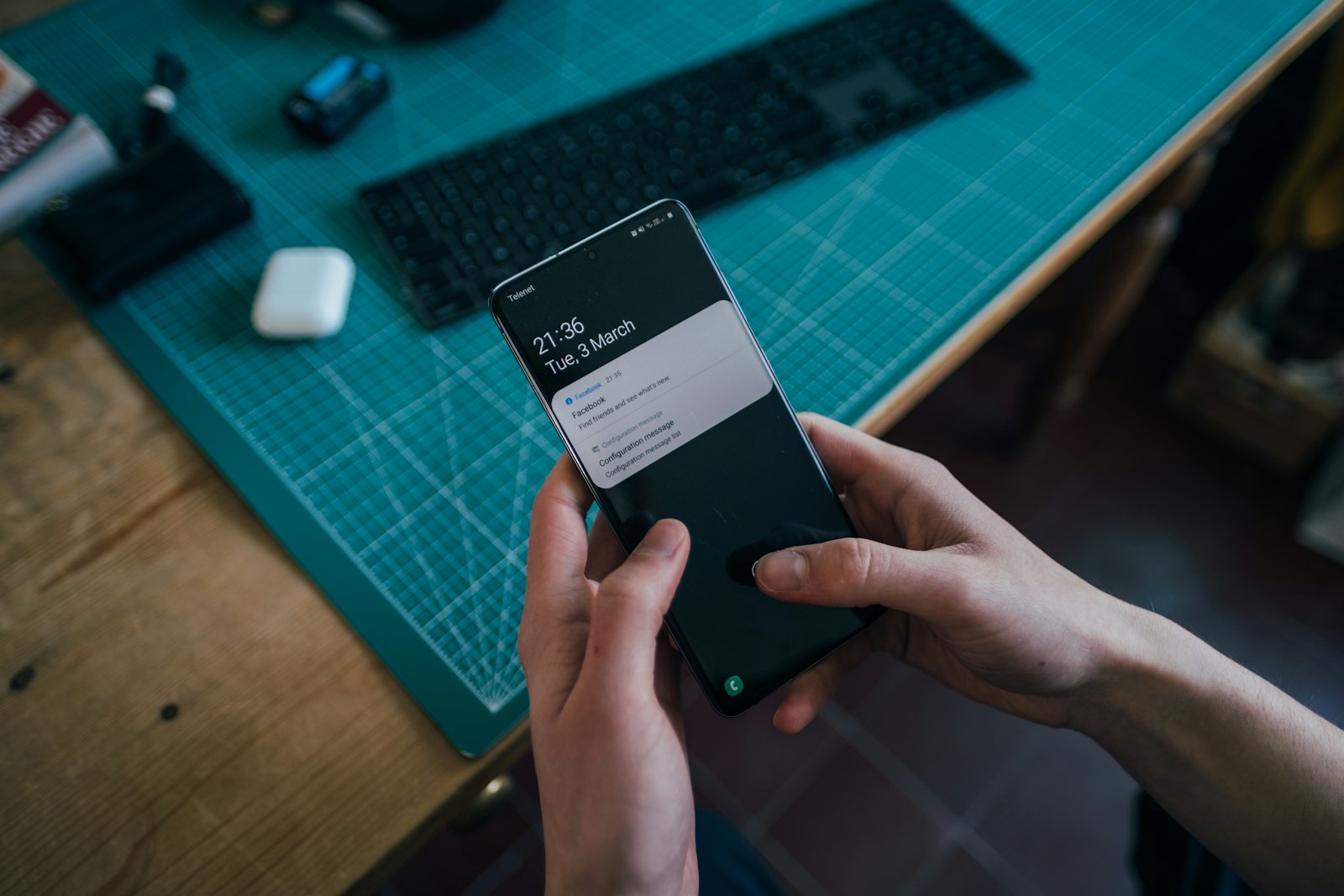 Jeune homme tenant son smartphone avec des notifications affichées à l'écran, illustration du smishing
