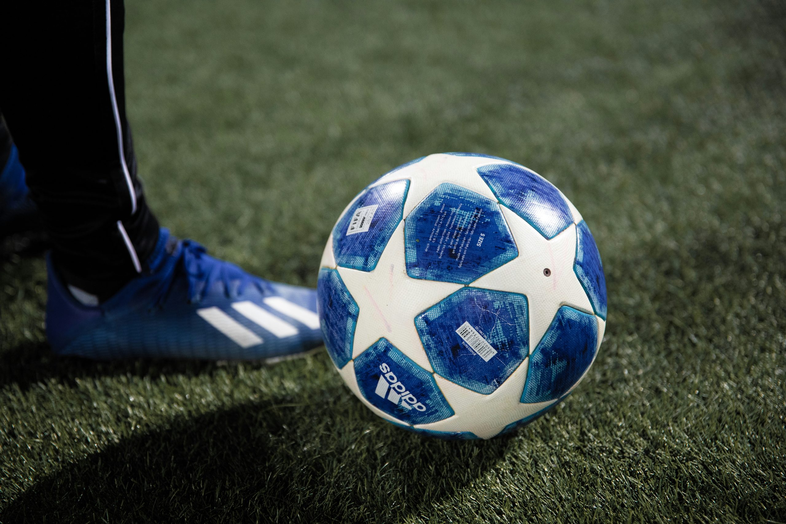 Ballon de football bleu et blanc sur un terrain, illustration des paris sportifs en ligne