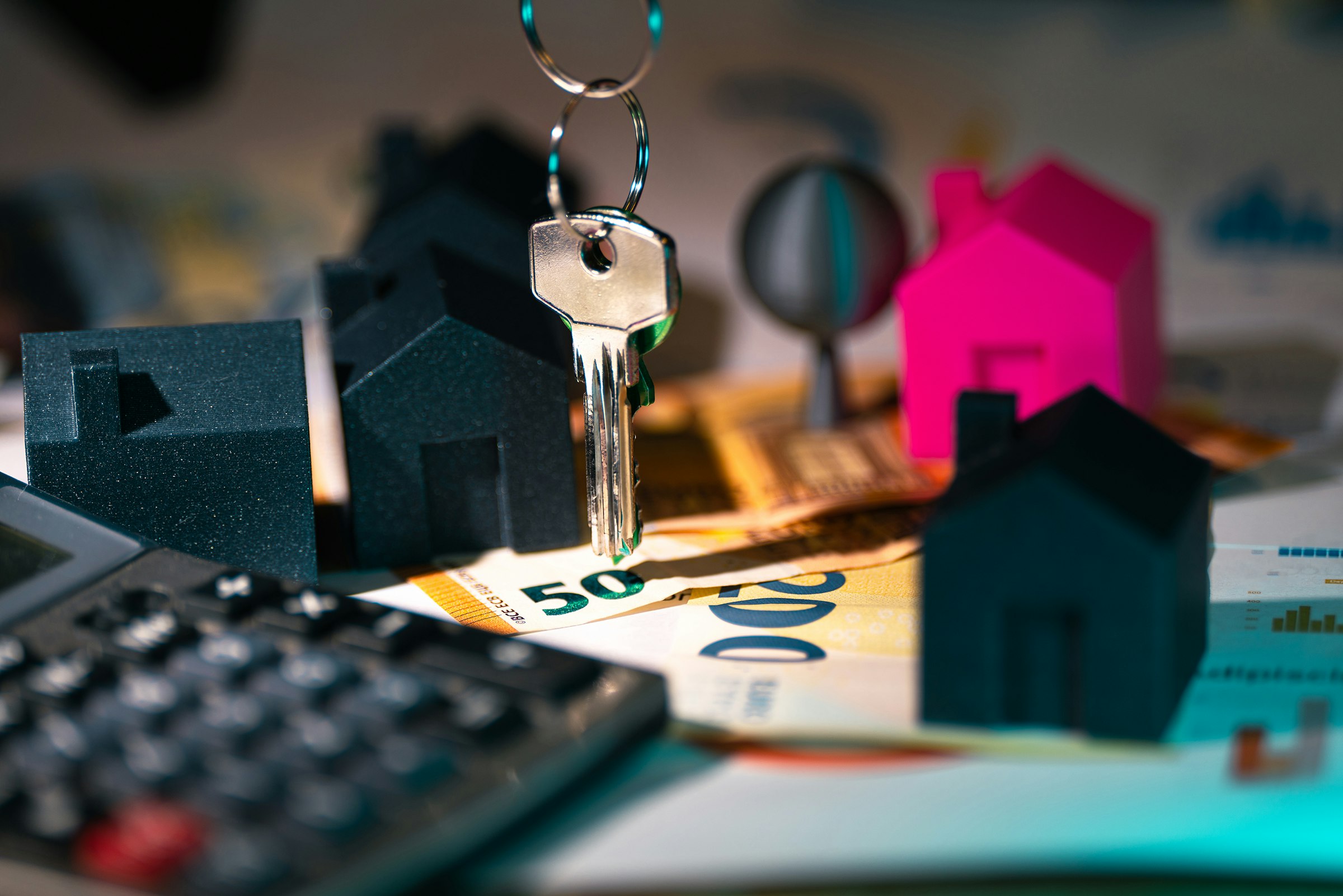 Calculatrice et maquette de maison utilisées pour simuler un crédit immobilier