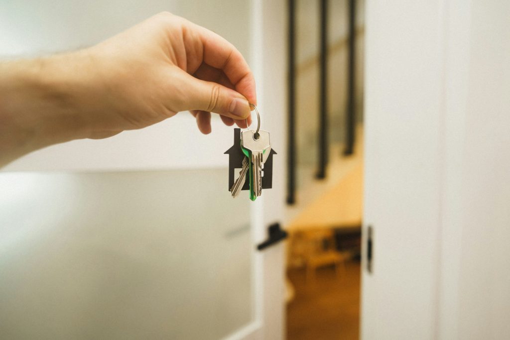 Main tenant une clé de maison, symbole de l'accès à la propriété après un crédit immobilier