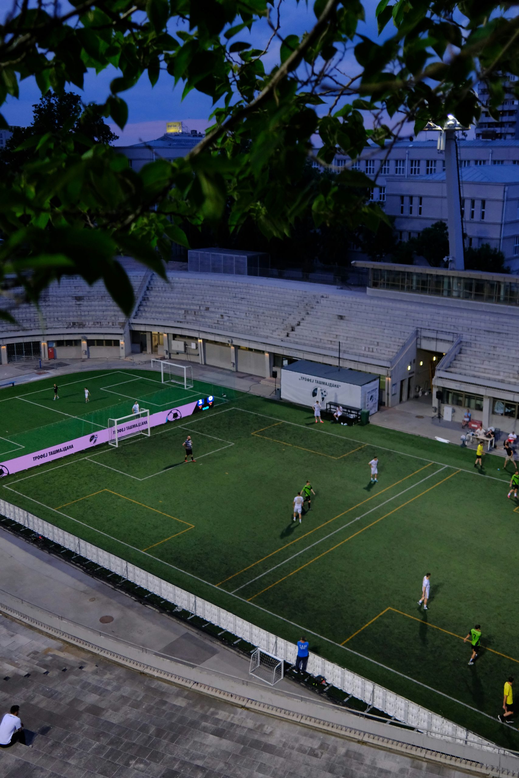 Joueurs de football sur un terrain de stade au crépuscule, ambiance de grand match