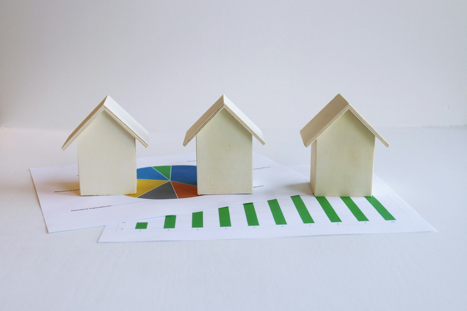 Maquettes de maisons posées sur un document de simulation des aides à la rénovation énergétique